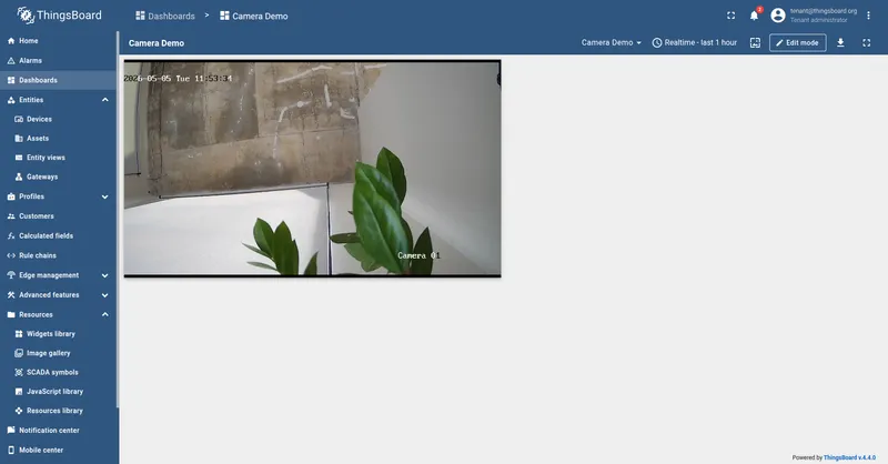 Camera Demo dashboard in view mode with the HLS Video Stream widget playing a live feed of an outdoor scene labeled Camera 01, with the in-frame camera timestamp visible.